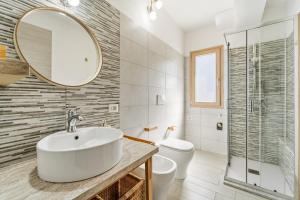 a bathroom with a sink and a toilet and a mirror at Casa Due Spighe in San Sperate +18 photos
