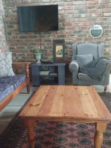a living room with a wooden coffee table and a couch at Harmony and Melody self catering in Bethlehem