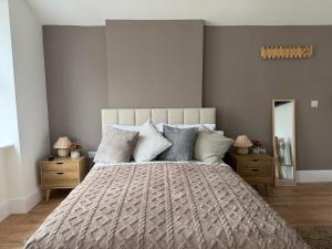 a bedroom with a large bed and a mirror at Glan Neigr Room 11 in Rhosneigr