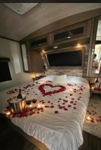 a bed covered in roses with candles and wine glasses at Sunset Combate in Cabo Rojo