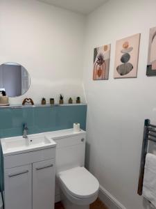 a bathroom with a white toilet and a sink at Glan Neigr Room 11 in Rhosneigr +20 photos