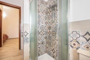 a shower in a bathroom with a tiled wall at Appartamento il Decimomiglio in Decimomannu +15 photos