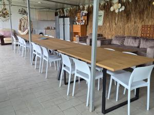 a large wooden table and chairs in a room at Pensiunea VADU in Vadu