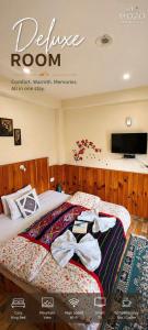 a hotel room with a bed with bows on it at MOZO Inn&Cafe Jibhi in Banjār