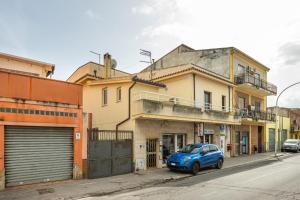 a blue car parked in front of a building at Appartamento il Decimomiglio in Decimomannu