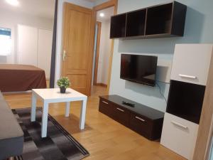 a living room with a small table and a tv at Loft Centrico Bahia 2 in Santander