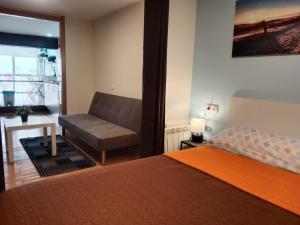 a bedroom with a bed and a couch at Loft Centrico Bahia 2 in Santander