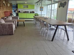 a room with a table and chairs and a kitchen at Pensiunea VADU in Vadu +56 photos