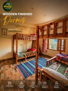a room with three bunk beds in a room at MOZO Inn&Cafe Jibhi in Banjār