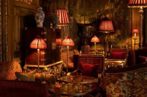 a living room with tables and chairs and lamps at Prestonfield House in Edinburgh