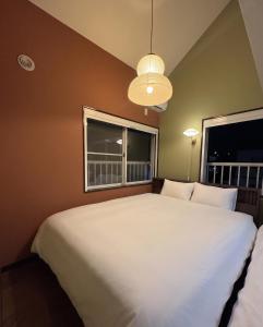 a bedroom with a large white bed and two windows at Shinjuku Topshot Hotel in Tokyo