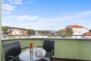 a table and chairs on a balcony with a view at Lotus Oliva Apart in Premantura