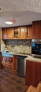 a kitchen with wooden cabinets and a stove top oven at La Casetta 23 in Perledo
