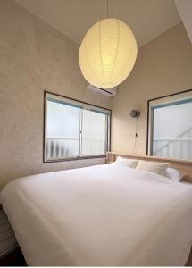 a bedroom with a large white bed and a lamp at Shinjuku Topshot Hotel in Tokyo +44 photos