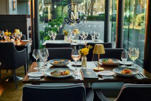 a wooden table with plates of food and wine glasses at Mespil Hotel in Dublin