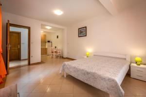 a bedroom with a large bed and a kitchen at Mango Apartment Petrovac in Petrovac na Moru