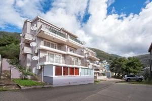 a building with a car parked in front of it at Mango Apartment Petrovac in Petrovac na Moru