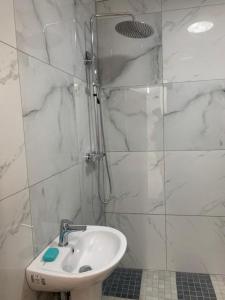 a white bathroom with a sink and a shower at Park View in Goodmayes
