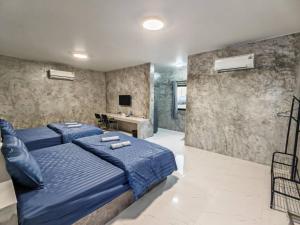 a bedroom with a blue bed and a desk at K-Am คราม อมตะ รีสอร์ต in Ban Yan Su
