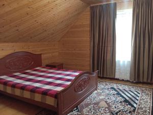 a bedroom with a bed in a wooden room at Caдиба Ксенія in Sheshory