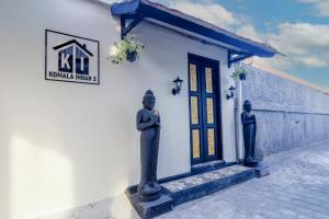 a building with two statues in front of a door at Komala Indah 2 in Badung