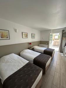 a room with three beds in a room with a door at La Garance in Bédoin +84 photos