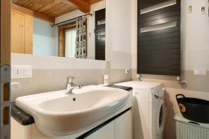 a bathroom with a sink and a washing machine at Loft Panorama By Immobilux in Rabbi +24 photos
