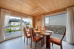 a dining room with a table and chairs and a large window at Ferienhaus Seewald in Seewald