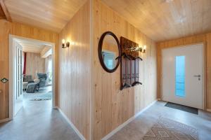 a hallway with wooden walls and a mirror on the wall at Ferienhaus Seewald in Seewald +25 photos