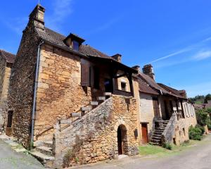 an old stone building with stairs on a street at La pomponnaise in Saint-Pompont