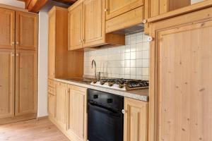 a kitchen with wooden cabinets and a black dishwasher at Loft Panorama By Immobilux in Rabbi