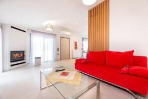 a living room with a red couch and a fireplace at Aelion Airport Residence By SEM in Artemida