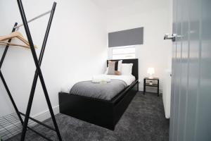 a bedroom with a bed with a black frame at Borough Street in Port Talbot
