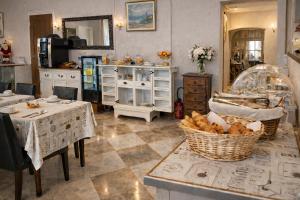 a kitchen with two tables and a basket of bread at Hôtel du Palais in Évian-les-Bains