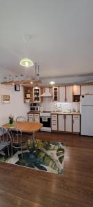 a kitchen with a wooden table and a kitchen with white appliances at Santariškės Apartment in Vilnius +20 photos