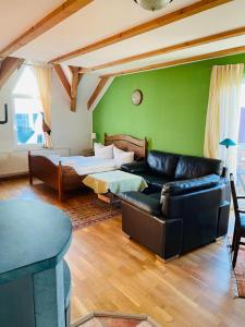 a living room with a leather couch and a bed at Dia Mare in Ueckeritz