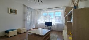 a living room with a table and a television at Santariškės Apartment in Vilnius