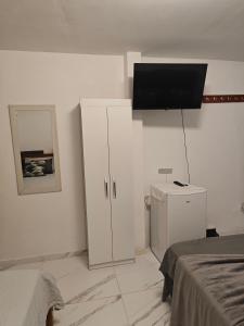 a bedroom with white cabinets and a flat screen tv at Suites Du'Mauro Terreo in Abraão