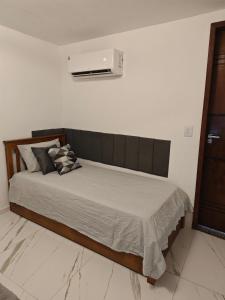 a bedroom with a bed with a air conditioner on the wall at Suites Du'Mauro Terreo in Abraão