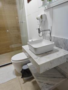 a bathroom with a sink and a toilet at Suites Du'Mauro Terreo in Abraão