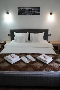 a bedroom with a bed with towels on it at Casa de la Nuc in Târgu Jiu