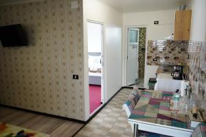 a living room with a table and a kitchen at Casa de la Nuc in Târgu Jiu