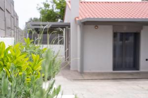 a white building with a door and some plants at Aelion Airport Residence By SEM in Artemida