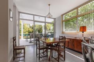a dining room with a table and chairs and windows at Villa Yantet - Conciergerieland in Soustons