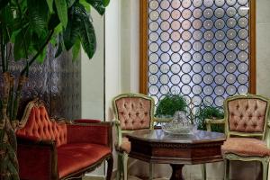 a room with two chairs and a table and a window at Hotel Commercio & Pellegrino in Venice +19 photos
