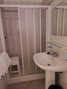 a white bathroom with a sink and a shower at Albergo La Maria in Fiumaretta di Ameglia