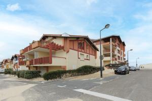 a building with a car parked next to a street at Aux Gourbets - Conciergerieland in Vieux-Boucau-les-Bains