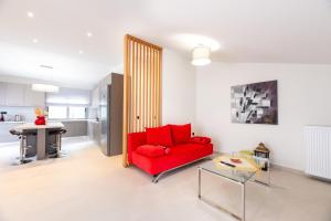 a living room with a red couch and a kitchen at Aelion Airport Residence By SEM in Artemida