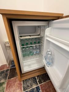 an open refrigerator with bottles of water in it at Anema e Core Salerno rooms in Salerno