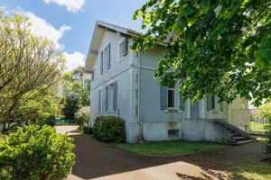 an old white house with trees in front of it at Villa Yantet - Conciergerieland in Soustons